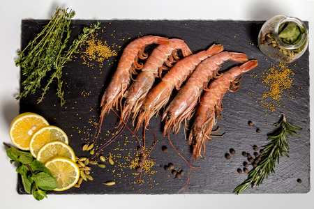 shrimp langoustine lie on a black plateの写真素材
