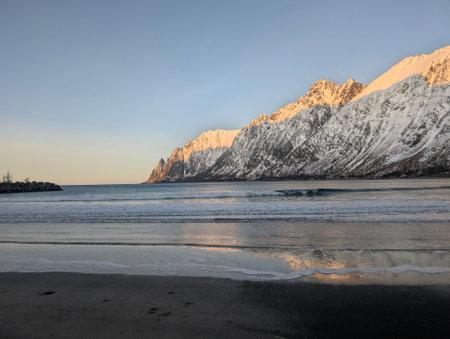 Majestic Snowy Mountains by Coastal Shoreの写真素材