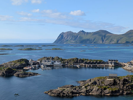 Scenic harbor with Nordic cabins and turquoise sea surrounded by mountainsの写真素材