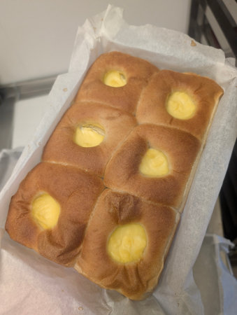 Tray of freshly baked sweet buns with vanilla custard fillingの写真素材