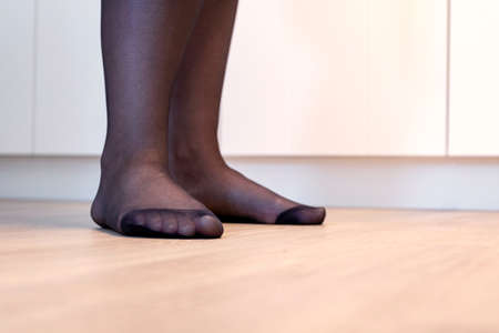 A portrait of the feet of a girl in black pantyhose with the nylon at the toes being reinforced.の写真素材