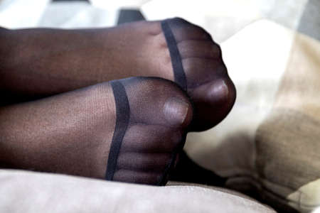 A portrait of the toes of a pair of feet wrapped in nylon pantyhose. The nylon stockings are reinforced at the toes.の写真素材