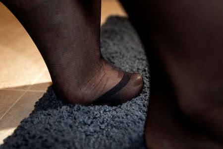 A close up portrait of the toes of a foot in black pantyhose. The nylon at the toes is reinforced and the girl is standing on the tip of her feet.の写真素材