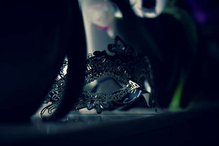 A portrait of a venetian mask lying on a marble windowsill ready to put on and go to a masked ball, halloween party or carnival.の写真素材