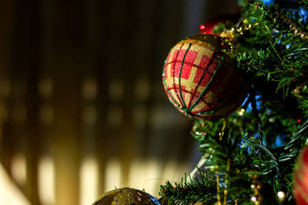 A portrait of a christmas ball hanging in a christmas tree together with other ornaments.の写真素材