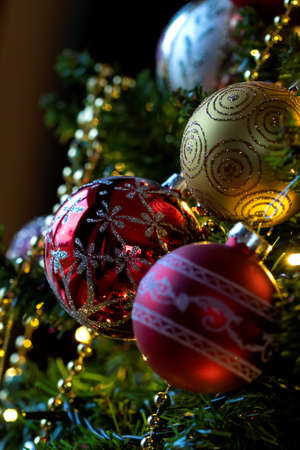 A holiday portrait of christmas balls garlands and lights hanging in a christmas tree during the holidays at the brink of a new year.の写真素材