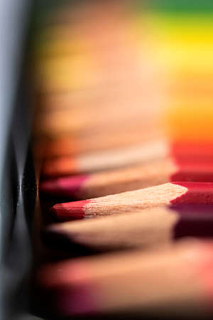 A portrait of the colorful tips of color pencils in a box lying next to eachoter making a gradually colored background.の写真素材