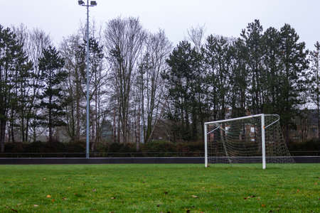 A portrait of a football goal on a grass field on a cloudy and rainy day.の写真素材