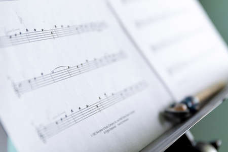 Brecht, Belgium - April 15 2020: A close up portrait of a music sheet with notes on it on a music stand. There is also a pencil on the stand to mark certain points on the notes of the classic piece.の写真素材
