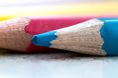 A macro portrait of a wooden blue color pencil lying in front of other colored pencils. It is used, because the tip is blunt, it is not as sharp anymore.の写真素材