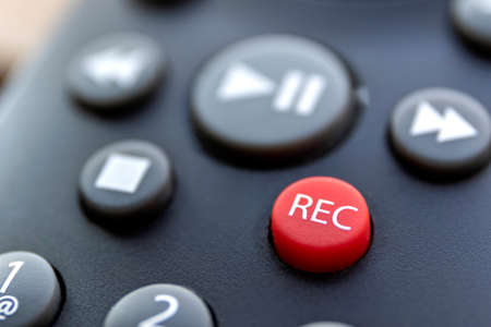 A close up portrait of the record button of a television or other multimedia device to start recording sound or a series or movie. it is surrounded by the buttons needed to play it again.の写真素材