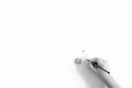 A minimalistic black and white abstract portrait of a hand of a person holding a pencil, drawing a...