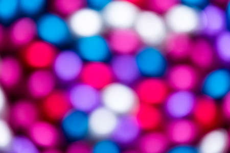 An abstract colorful blurry art background of different colors. The bokeh balls are pink, red, white, purple and blue.の写真素材