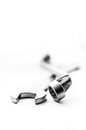 A black and white art portrait of a open end wrench and a box end wrench lying on top of eachother. The metal tools are lying on a white background.の写真素材