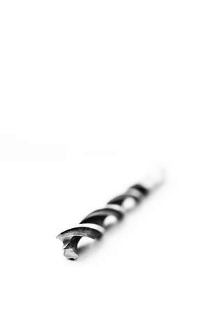 A black and white studio portrait of a spiral high speed steel wood drill bit on a white background. The metal tool is used to drill holes into wood for repair or construction or build work.の写真素材