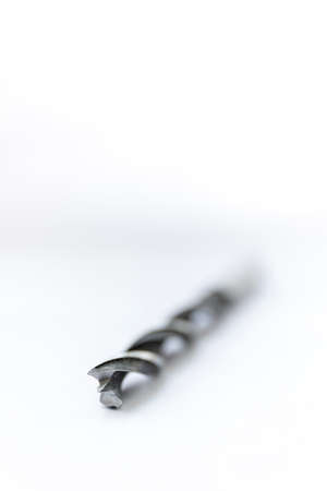 A black and white studio portrait of a spiral high speed steel wood drill bit on a white background. The metal tool is used to drill holes into wood for repair or building or construction work.の写真素材
