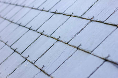 A close up portrait of a blue, black slate tile roof. The long lasting natural shingles are placed...