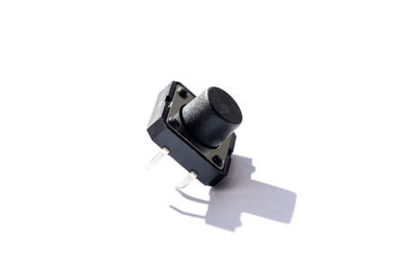 A close up portrait of a small push button. The electric component is used in electronics on a on...