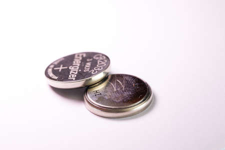 Brecht, Belgium - March 5 2022: A studio portrait of two coin cell, button or watch Energizer batteries stacked on top of each other. The tiny single use power supplies are ready for use.のeditorial素材