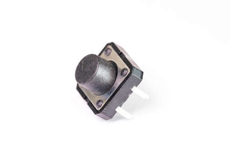 A close up portrait of a small push button. The electric component is used in electronics on a PCB...