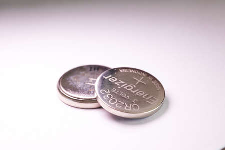 Brecht, Belgium - March 5 2022: A studio portrait of two button cell, coin or watch Energizer batteries stacked on top of each other. The tiny single use power supplies are ready for use.のeditorial素材