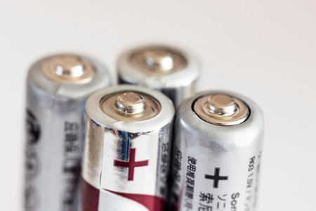 A close up portrait of the plus or positive side of a couple of triple A or AAA batteries standing upright.の写真素材