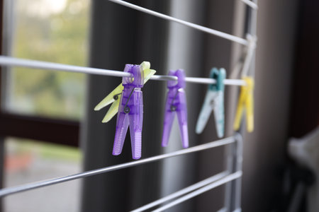 A portrait of multiple washingpins hanging on a laundry rack. The pens or clamps are used to hang...