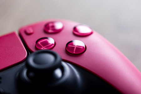 Brecht, Belgium - January 26, 2023: A close up portrait of the classic buttons of a sony playstation 5 cosmic red wireless controller. The triangle, square, circle and cross button are visible.のeditorial素材