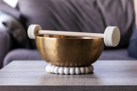 A large singing bowl, also called a himalayan bowl, with a mallet lying on top of it to make a relaxing sound. The object is used for relaxation, meditation and therapy to relieve stress.の写真素材
