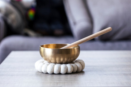 A portrait of a tibetan singing bowl, also called a himalayan bowl, with a mallet standing in it to make a relaxing sound. The object is used for relaxation, meditation and therapy to relieve stress.の写真素材