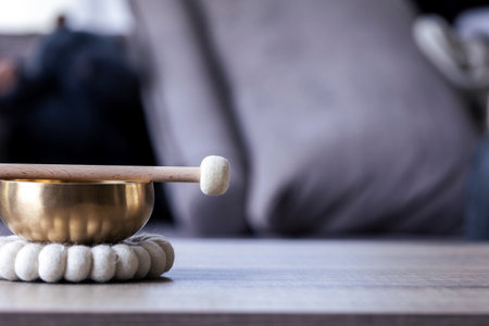 A close up portrait of half of a tibetan singing bowl with a mallet on it and some negative space to the right. The himalayan bowl is used for stress relief, relaxation and meditation.の写真素材