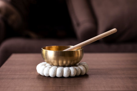 A tibetan singing bowl, also called a himalayan bowl, with a mallet standing in it to make a relaxing sound. The object is used for therapy to relieve stress and relaxation, meditation.の写真素材