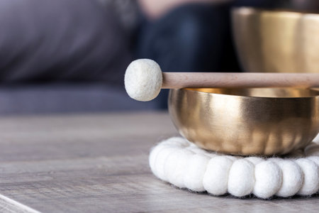 A portrait of half of a tibetan singing bowl with a mallet on it and 7negative space to the left. The himalayan bowl is used for stress relief, relaxation and meditation.の写真素材