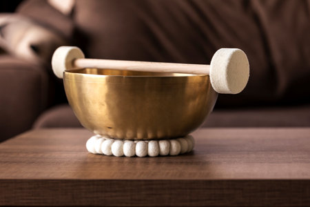 A closeup of a large himalayan bowl, also called a singing bowl, with a mallet lying on top of it to make a relaxing sound. The object is used for relaxation, meditation and therapy to relieve stress.の写真素材