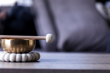 A portrait of half of a tibetan singing bowl with a mallet on it and some negative space to the right. The himalayan bowl is used for stress relief, relaxation and meditation.の写真素材