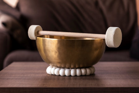 Portrait of a large singing bowl, also called a himalayan bowl, with a mallet lying on top of it to make a relaxing sound. The object is used for relaxation, meditation and therapy to relieve stress.の写真素材