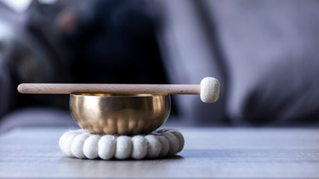 A close up of a tibetan singing bowl or himalayan bowl, with a mallet lying on top of it to make a relaxing sound. The object is used for therapy to relieve stress and meditation, relaxation.の写真素材