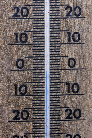 A close up portrait of a thermometer gauge indicating a temperature measurement of zero degrees celcius. The instrument uses blue colored mercury.の写真素材