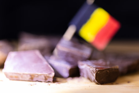 A bright portrait of some rough cut pieces of tasty delicious brown dark Belgian chocolate lying on...