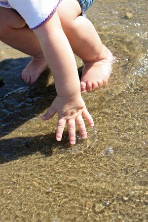 hands of a toddler feeling the waterの写真素材