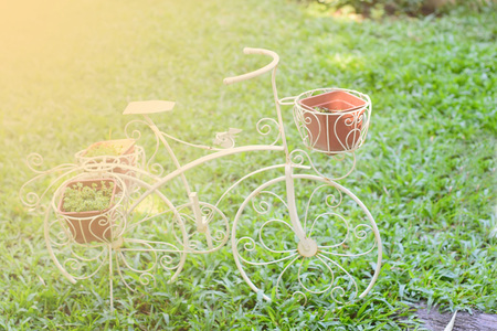 White bike on the grass in the park. /The design concept layout of vintage bikes. /A warm tone.の写真素材