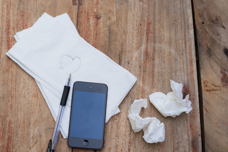 white tissue pen and mobile phone on tableの写真素材