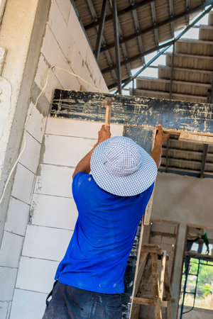 hands with hammer hitting a nailの写真素材