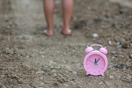 alarm clock on soil or dirt with legs
