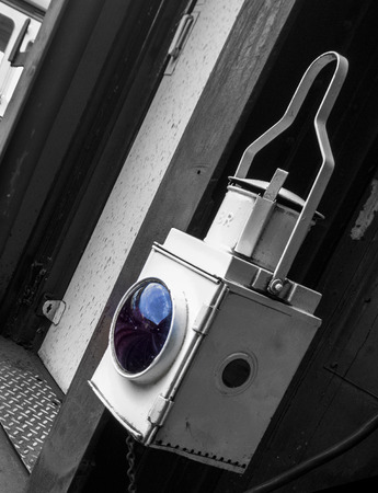 Showing the back of a Steam train carriage with a white lantern showing a reflection of the railway track and station in the glass windowの写真素材