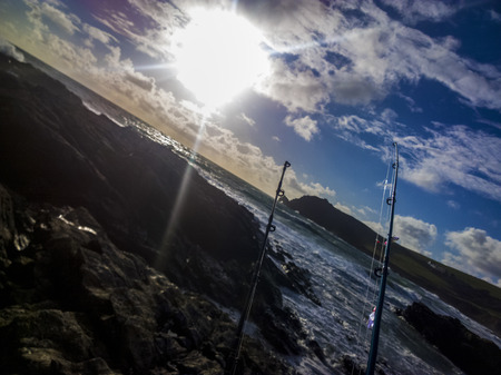 Fishing on a rocky beach in Devon UK during sunsetの写真素材