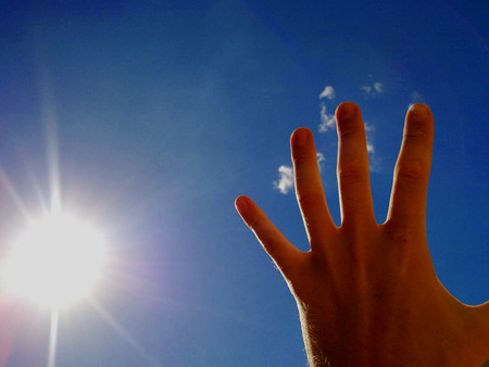 Hand blocking the sun on a beach in Spainの写真素材