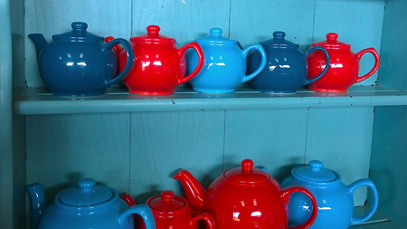 Red and blue tea pots on a dresserの写真素材