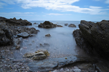 Rocks and skies on a beach long exposure usedの写真素材