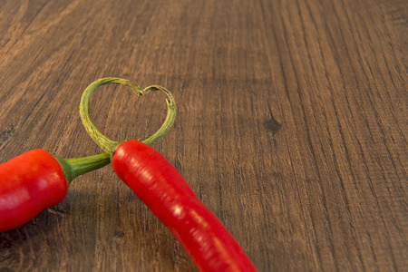 Showing 2 chillies with their stalks placed together to form a heartの写真素材